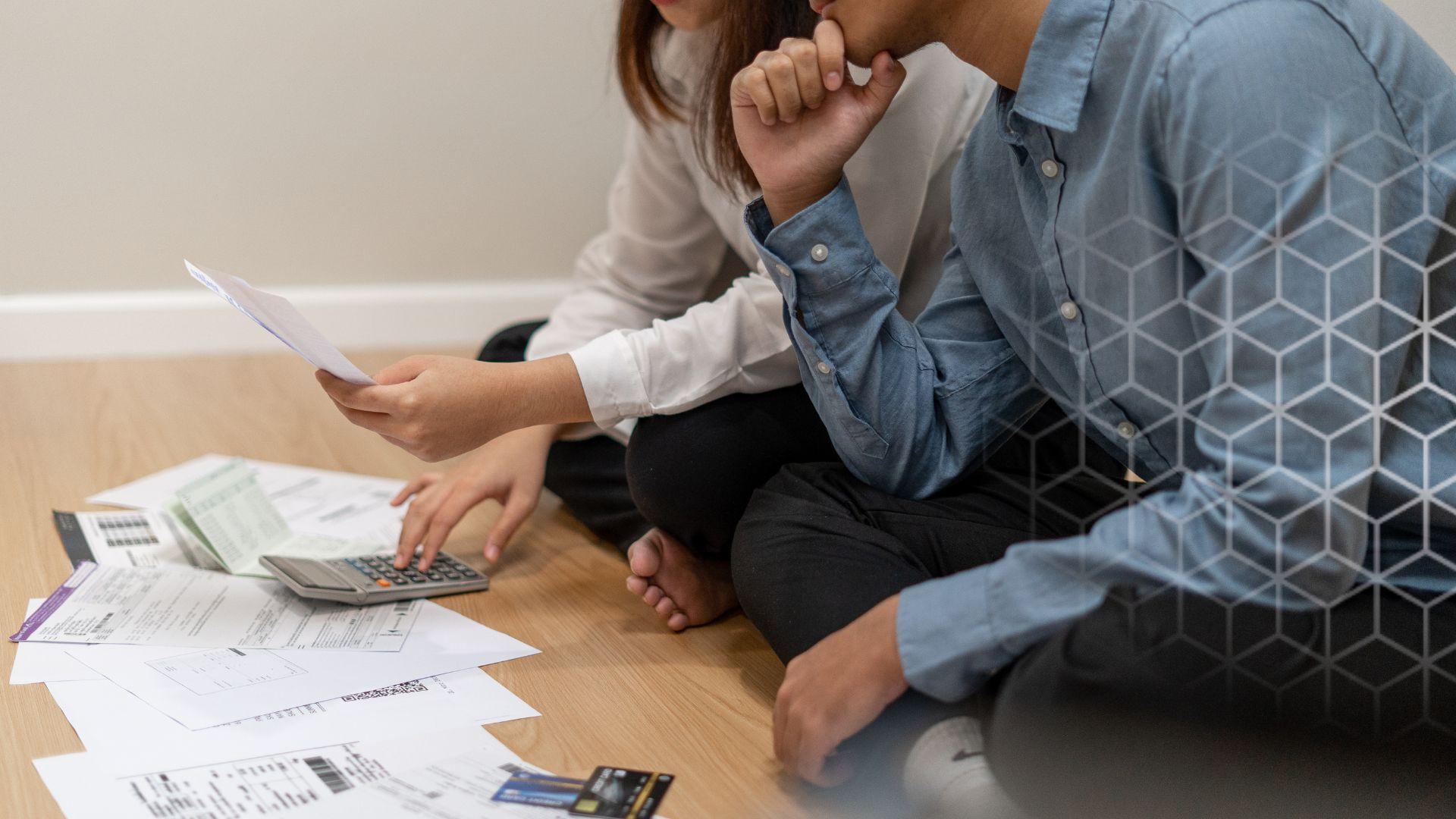 a man and a woman look at bills