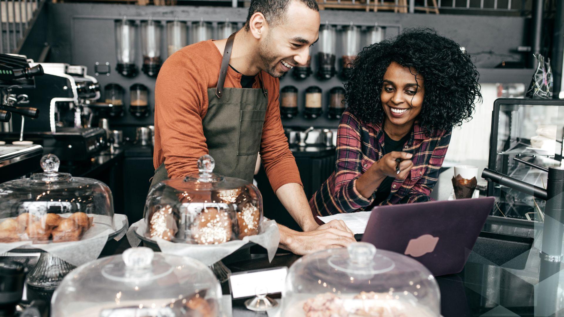 A man and a woman smile together in a cafe
